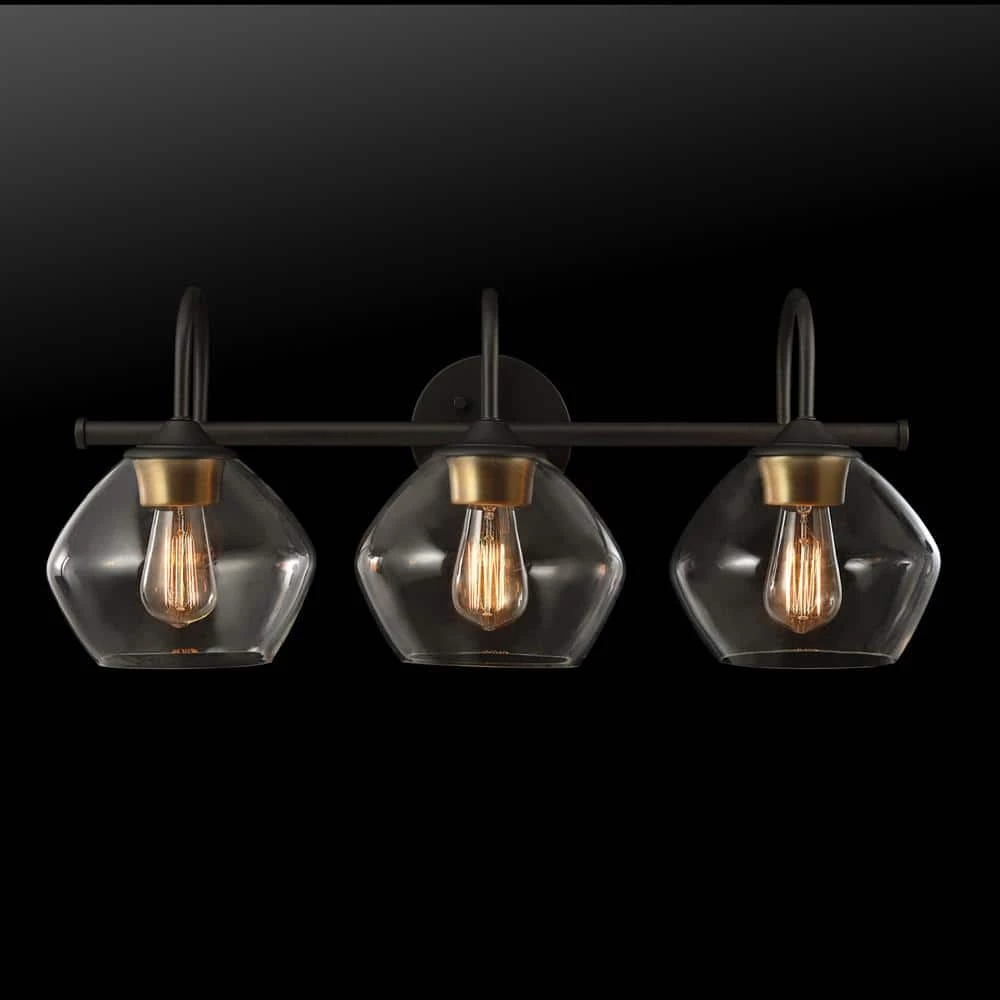 Harrow 26.3 in. 3-Light Dark Bronze Vanity Light with Antique Brass Accents and Clear Glass Shades by Globe Electric 2 Harrow 26.3 in. 3-Light Dark Bronze Vanity Light with Antique Brass Accents and Clear Glass Shades by Globe Electric - Image 2